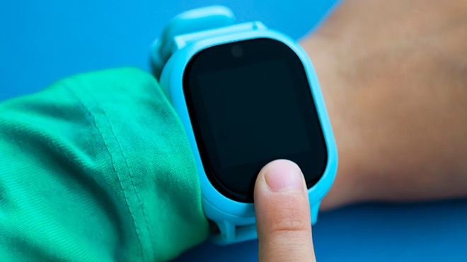 child checking a fitness tracker watch